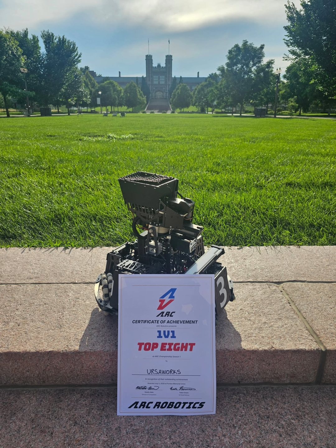 Robot with the ARC 1v1 Top Eight certificate in front of Brookings Hall